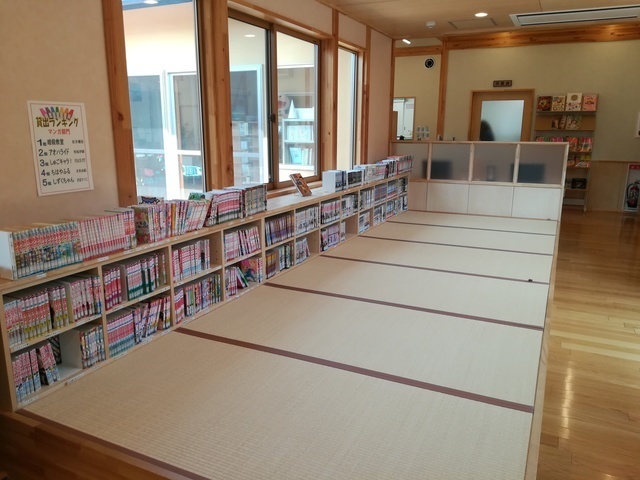 窓際に漫画が配架された畳敷きの小上がり